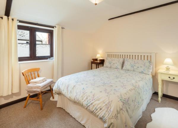 Double bedroom with bed, bedside tables with lamps and an armchair.
