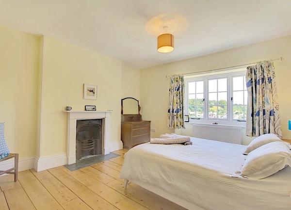 Double bedroom with wood floor, bed and dressing table.