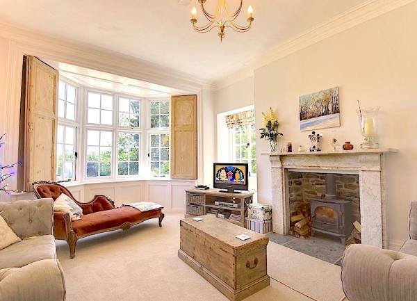 Lounge with armchairs, chaise-lounge and woodburner.