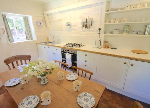 Fitted kitchen with appliances and dining table.