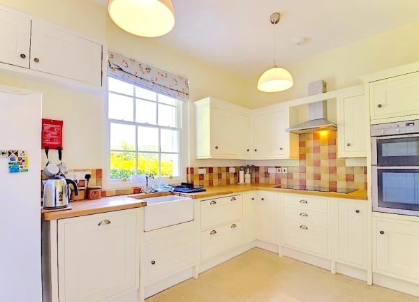 Fitted kitchen with oven, dishwasher, sink and fridge.