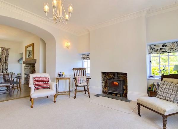 llounge with armchairs, coffee table and woodburner.