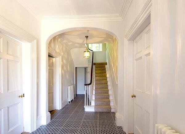 Carpeted hallway with stairs.