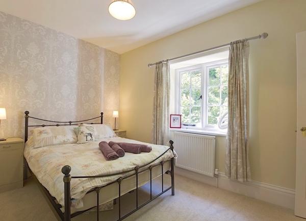 Double bedroom with bed, and bedside cabinets with table lamps.