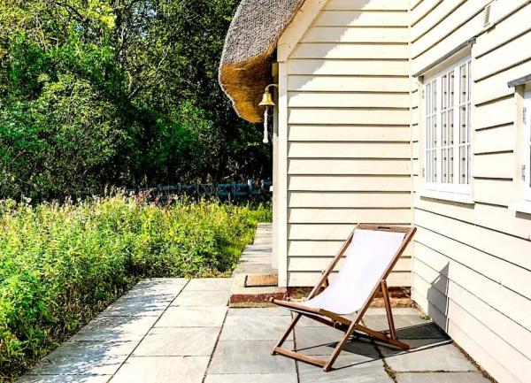 Garden patio outside a clapperboard-walled cottage.