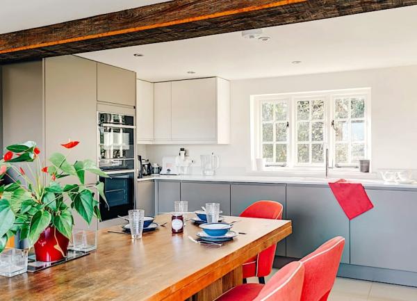 Wood dining table and fitted kitchen units.