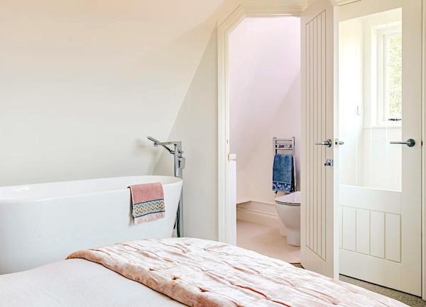 Doiuble bedroom with bed and a bath.