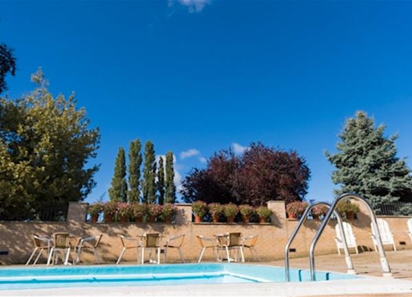 Open air swimming pool and terrace with sun-loungers.