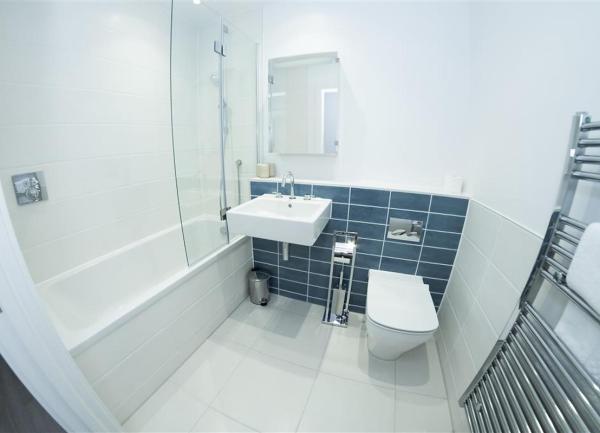 Bathroom with shower/bath WC, wash basin and heated towel rail.