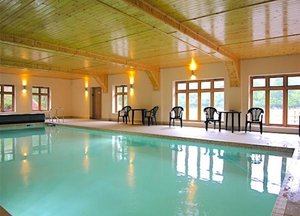 Large indoor swimming pool with poolside chairs.