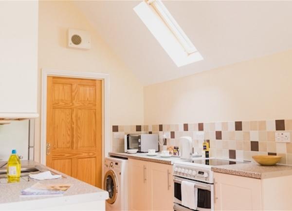 Fitted kitchen with oven and washing machine.