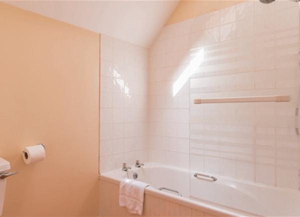 Bathroom with bath with overhead shower.