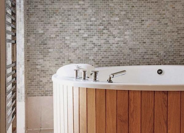 Wood-panelled indoor hot tub.