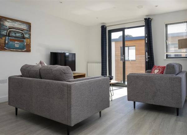 French windows, two sofas and TV in the lounge area