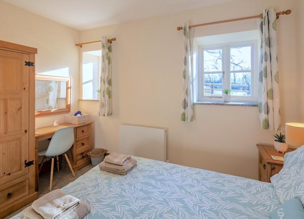 Double bedroom with bed, wardrobe and dressing table.