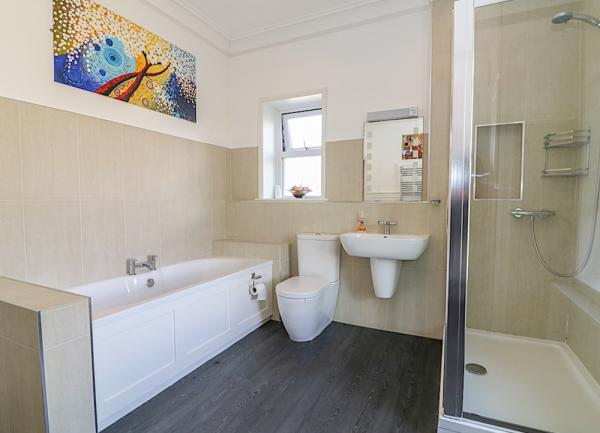 Bathroom with bath, shower, wash basin and toilet.