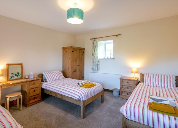 Triple bedroom with zip-and-link beds, dressing table and wardrobe.