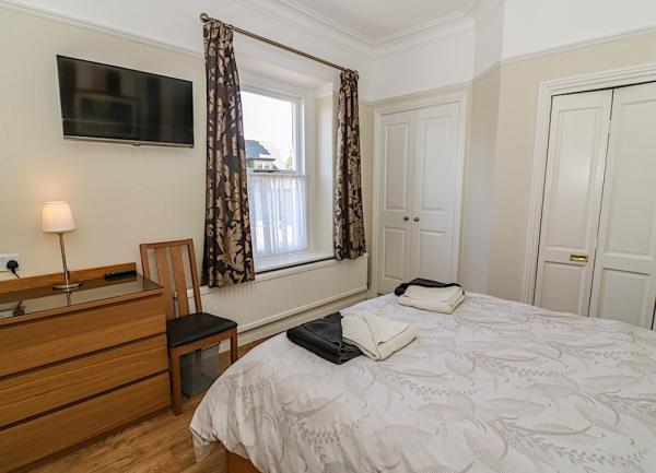 Double bedroom with bed and chest-of-drawers.