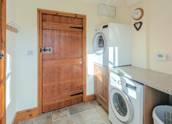 Utility room with washing machine and tumble dryer.