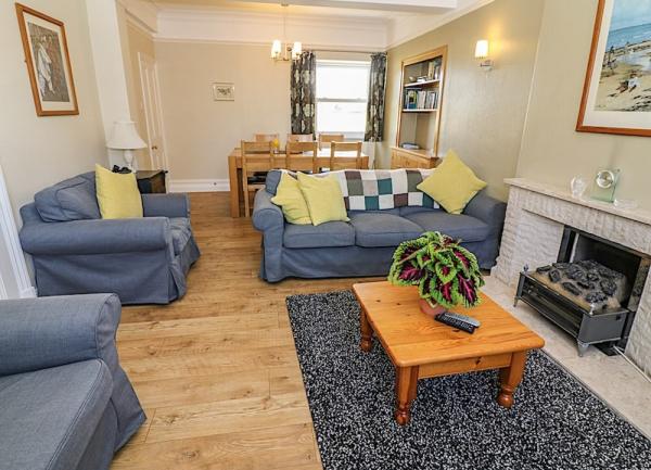 Lounge-diner with sofa, armchairs, coffee and dining table.