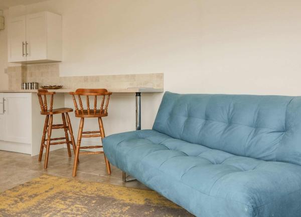 Lounge and dining area with sofa and wooden chairs.