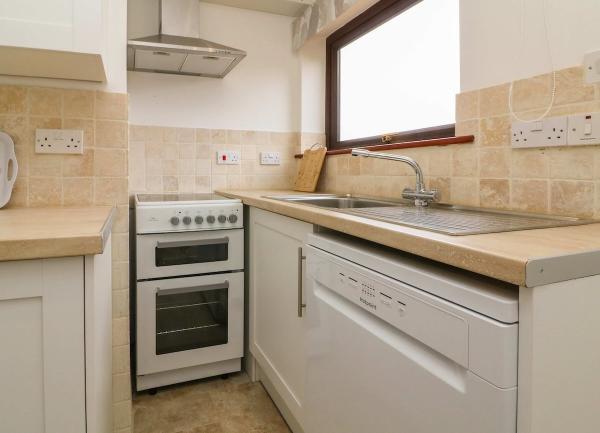 Kitchen with sink, oven and worktops.