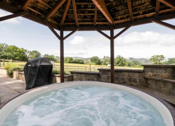 Hot tub under shelter offering rural views.
