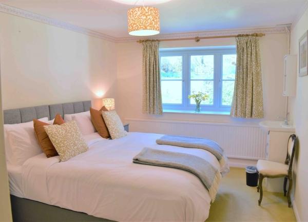 Double bedroom with bedside lights, bed and armchair.
