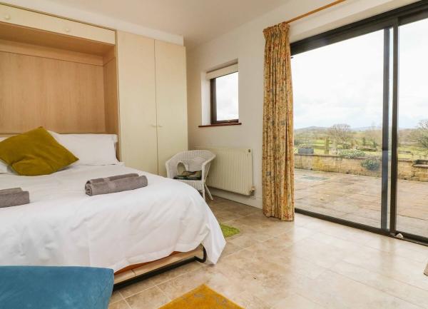 Double bedroom with bed armchair and large sliding glass doors.
