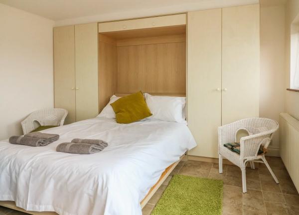 Double bedroom with bed and two armchairs.