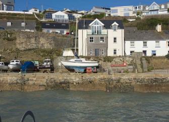 Waterfront terrace overlooks a harbour with small boats stored on the Quay.