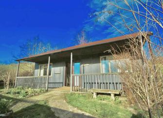 A cricket pavilion with a verandah converted to a holiday lodge.