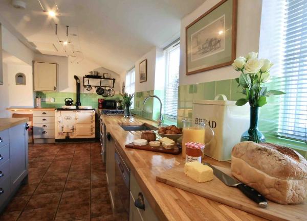 Long kitchen with wooden worktops and lots of appliances.