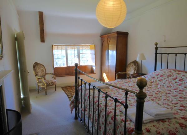 Double bedroom with large bed, armchair and bedside cabinets.