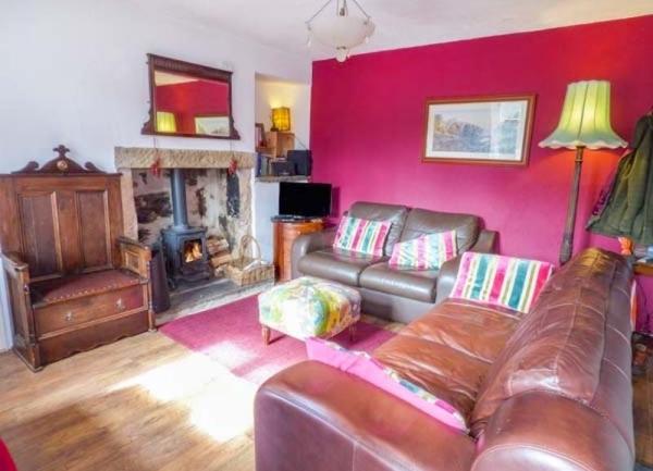 Lounge with two leather sofas and antique armchair.