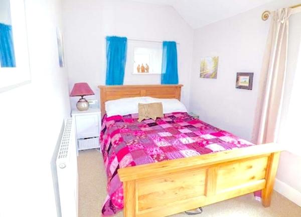 Double bedroom with bed, bedside cabinet and table light.