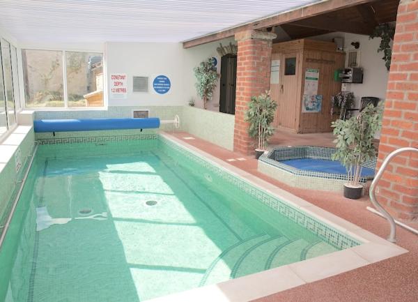 indoor heated swimming pool with a hot tub on its terrace.