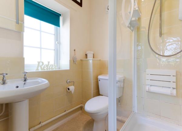 Bathroom with a shower, toilet and washbasin.