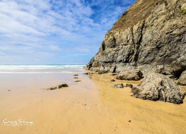 Rugged cliffs overlook a sandy Somerset beach at low tide.