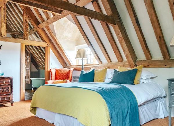 Spacious double bedroom with bed, dripo-leaf table and large ornate table lamps.