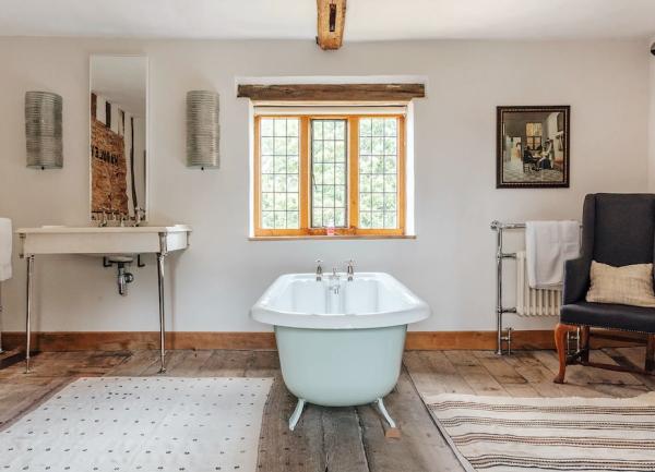 Bathroom with a Victorian-style bath, washbasin and armchair.