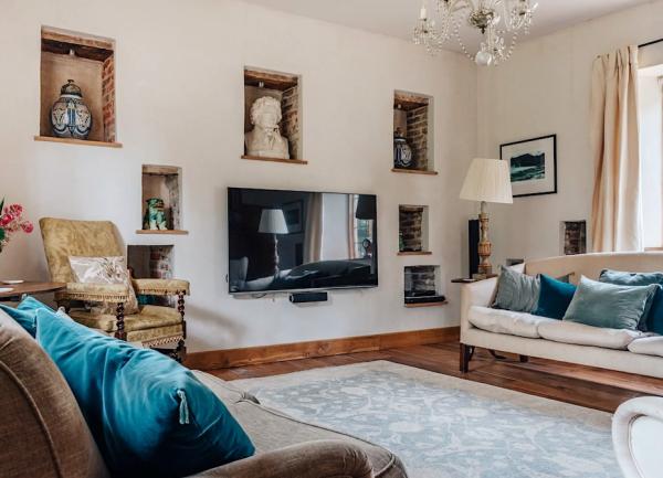 Lounge with large sofas, widescreen TV and an armchair.