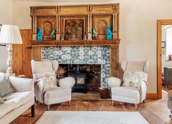 Lounge with tiled fireplace and matching wingback armchairs and sofa.