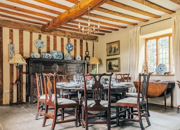 Mezzanine floor beneath arched oak beams, with arm chairs and a tea table.