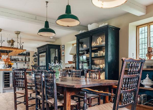 A dining area with an oak table at one end of a kitchen.