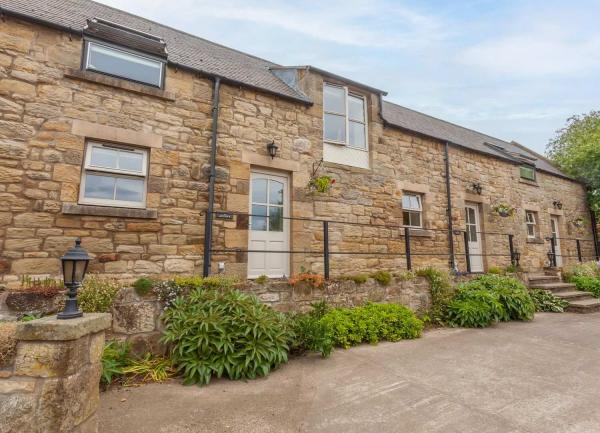 Exterior of a stone-built, semi-detached holiday cottage in Alnmouth.
