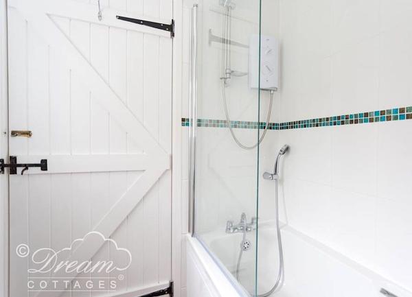 Bathroom with a bath with an overhead shower.