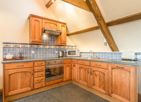 Pine fitted kitchen units and cookery appliances.