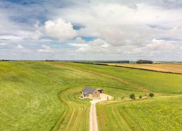 A remote, rural holiday cottage amidst large open fields.