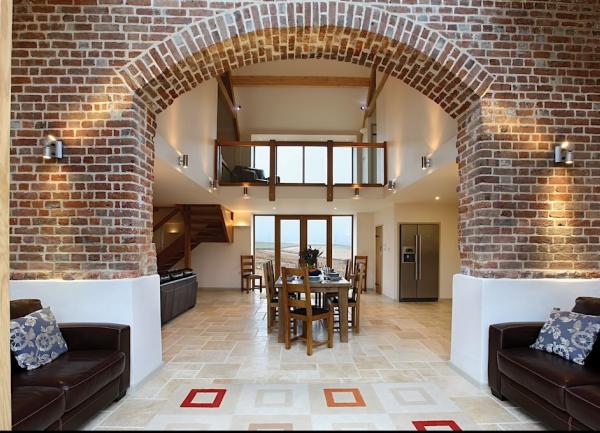 A lounge and dining room separated by a large brick arch.